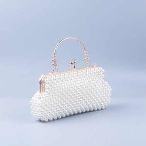 Close-up of woven white pearls and golden metallic handle on a shell-style evening bag