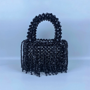 Close-up of black beaded handbag with fringe tassels and intricate woven craftsmanship