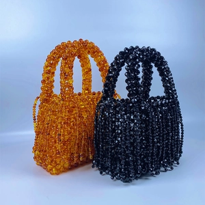 Detail of handmade beaded handbags in amber and black with fringe tassel accents