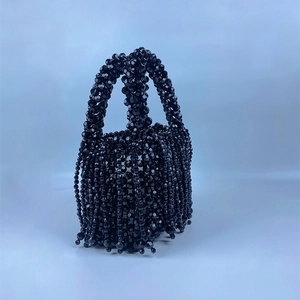 Detail view of handcrafted black beaded handbag featuring elegant tiered tassel fringe accents