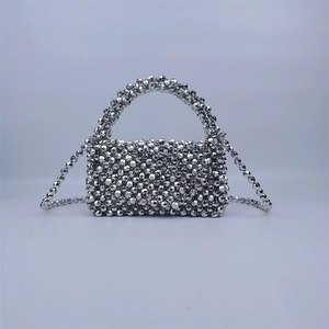 Detail view of sparkly silver beaded mini bag with woven bead handle and chain