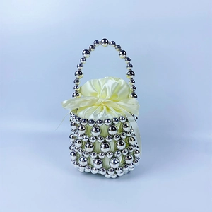 Detail of silver beaded hollow handbag with cream satin drawstring lining and bow
