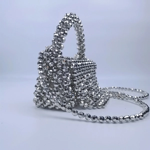 Macro shot of silver beaded crossbody bag detailing faceted beads and metallic texture