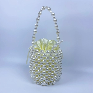 Detail of handmade pearl bucket bag featuring white beads and a satin drawstring liner