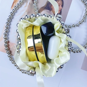 Detail of beaded bucket bag interior with silk pouch holding lipstick and cosmetics