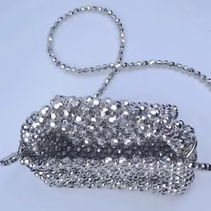 Detailed top view showing silver beaded construction and chain strap of mini clutch bag