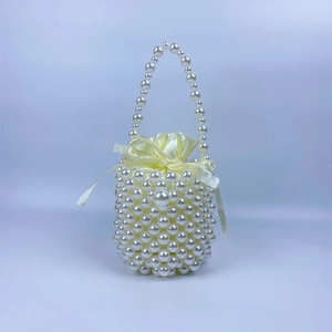 Detail of handmade pearl beaded bucket bag with elegant satin drawstring inner pouch