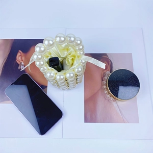 Detail of beaded pearl handbag with satin lining holding a lipstick in lifestyle setting