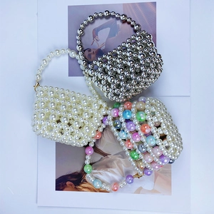 Close-up of handmade beaded bucket bags in silver, white pearl, and colorful styles