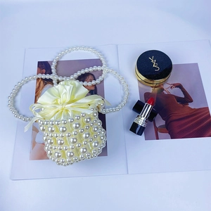 Macro shot of pearl beaded bucket bag with drawstring liner and elegant pearl handle