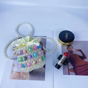 Detailed view of handmade beaded bucket bag with colorful pearls and satin drawstring