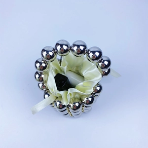 Detail of silver beaded mini handbag with satin drawstring lining and metallic weave