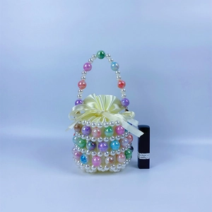 Macro detail of handmade colorful beaded pearl bucket bag with satin drawstring liner