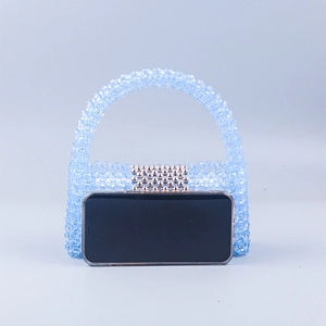 Détail d'un sac à main en perles bleues avec fermoir en métal argenté et tissage