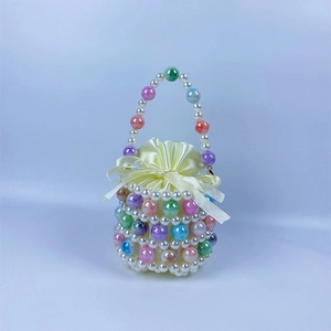 Detail of handmade beaded bucket bag featuring colorful pearls and satin drawstring pouch