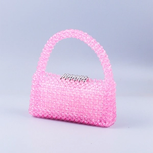 Détail d'un sac à main rose fait main avec des perles transparentes et un fermoir chic