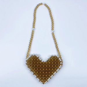Detail of amber beaded heart bag with white pearl border trim and stylish woven strap