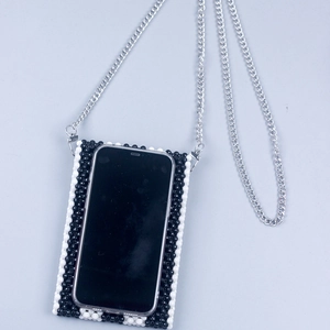 Detail view of handmade beaded crossbody phone bag with black and white beads and chain