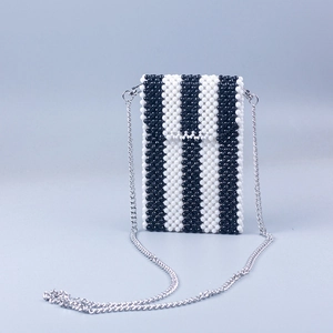Detail of handmade beaded phone bag featuring black and white vertical stripe pattern
