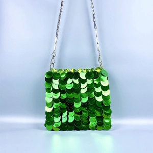 Detail of green sequin scale pattern on a shoulder bag with silver metal chain strap