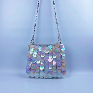 Detail of shimmering iridescent sequins on a French style crossbody bag with metal chain