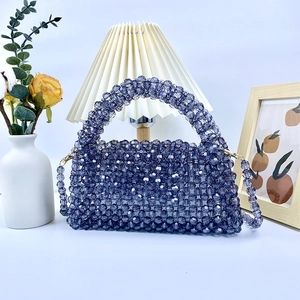 Detalle del bolso de cuentas azul oscuro tejido a mano con herrajes dorados