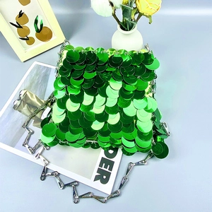 Detailed view of emerald green sequins with fish scale pattern and silver chain strap