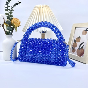Detalle del bolso de cuentas acrílicas azules con cuentas transparentes y asa rígida