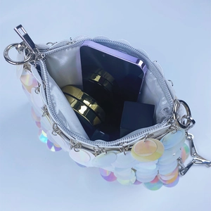Detail view of colorful sequin bucket bag showing interior capacity for phone and cosmetics