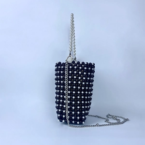 Close-up of handmade pearl weave pattern on black and white mini crossbody bucket bag