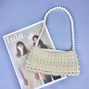 Vue détaillée du sac à bandoulière en perles fait main sur un fond de magazine