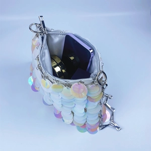 Detail view of pearlescent sequin bucket bag showing interior space and metal chain