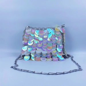Macro view of iridescent circular sequins and silver metal link chains on crossbody bag