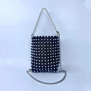 Close-up of handmade checkerboard pearl bead bag with metallic chain and handle