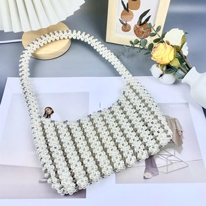 Détail du sac hobo tissé en perles blanches avec des touches de perles argentées