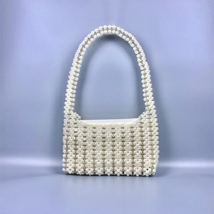 Détail du sac à main tissé en perles avec billes argentées et doublure en satin