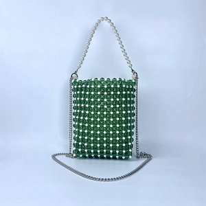 Close-up of green and white handmade beaded bag with pearl handle and silver chain strap