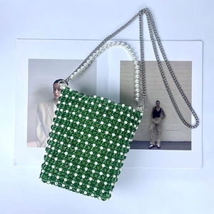 Detail of green and cream beaded mini crossbody bag with pearl handle and metal chain