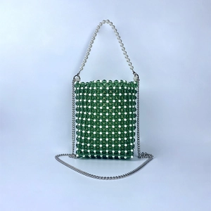 Detail of green and white woven bead handbag with pearl handle and silver chain strap