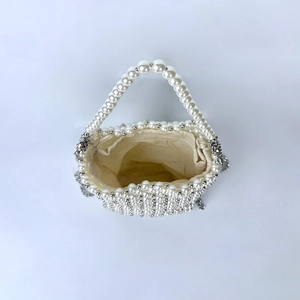 Top view of handmade pearl beaded handbag with silver accents and cream canvas liner