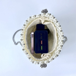 Detail showing the inner drawstring pouch and capacity of the pearl woven bucket bag