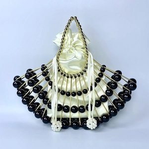 Detail of fan-shaped evening bag with gold metal frame, black beads and satin drawstring pouch