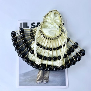Detail of fan-shaped beaded evening bag with black beads and gold-tone metal rods