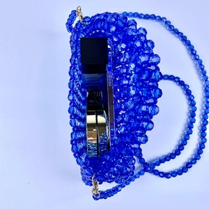 Vista superior del bolso de cuentas azules mostrando espacio para móvil y maquillaje