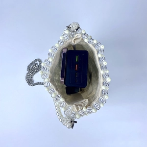 Detailed top view of handmade pearl mini bag showing storage capacity for a phone and power bank