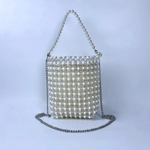 Detailed macro view of handcrafted beaded mini bag with pearl handle and silver chain strap