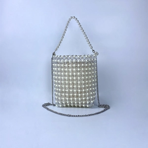 Detail of hand-woven beaded mini bag with pearl handle and silver metal chain strap
