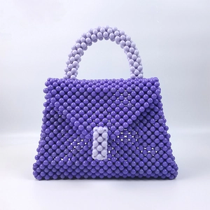 Dettaglio borsa fatta a mano in perline viola con trama intrecciata e finitura lucida