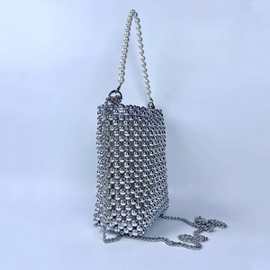 Close-up of silver beaded mini bag featuring a faux pearl handle and metal chain strap