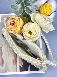 Sac à main artisanal en perles blanches avec fermeture éclair dans un décor élégant